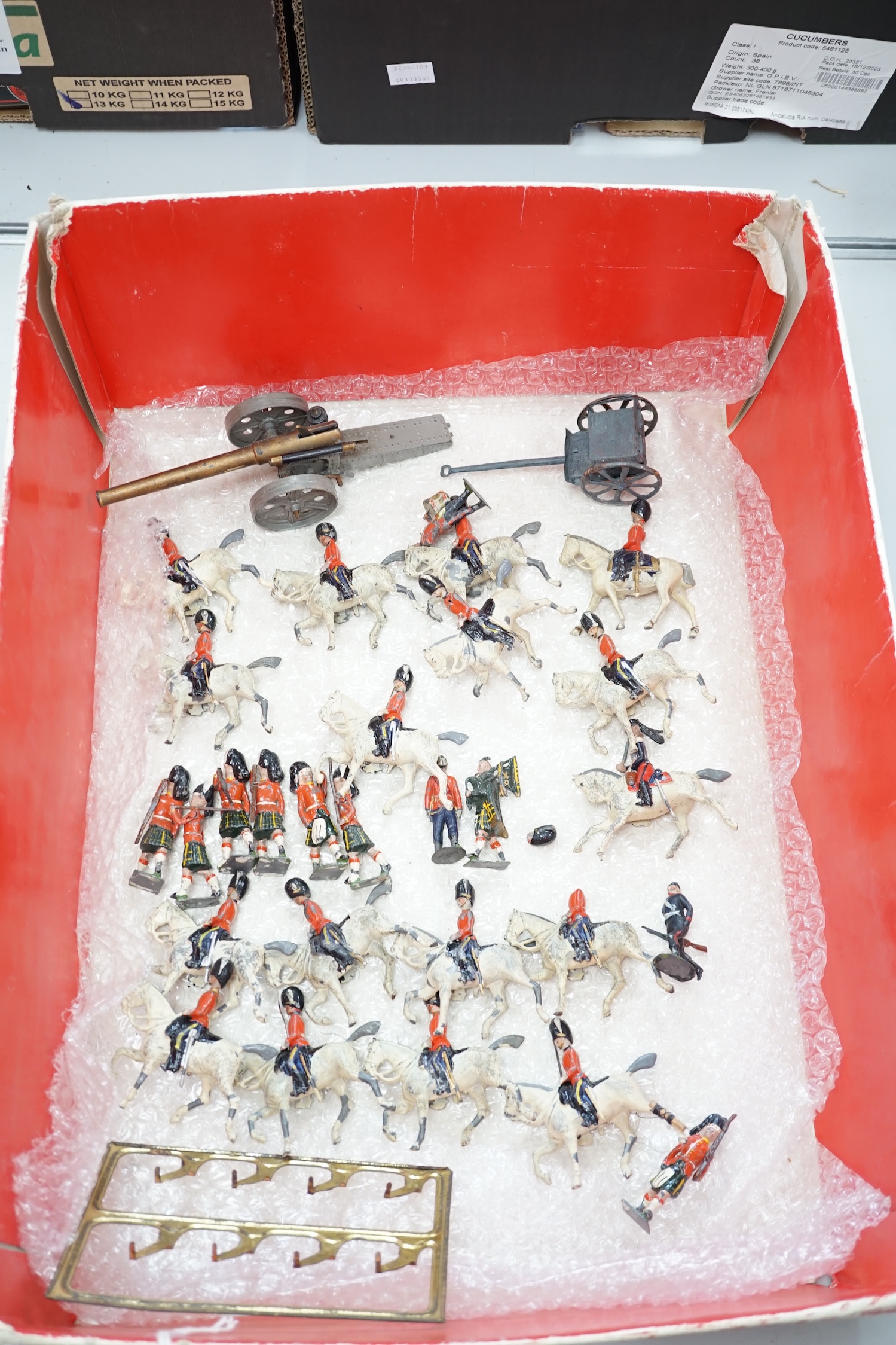 Forty-four early twentieth century Britains, etc. cavalry and infantry soldiers including; Scots Guards, mounted Grenadier Guards, bandsmen, etc. together with a field gun and tinplate lumber